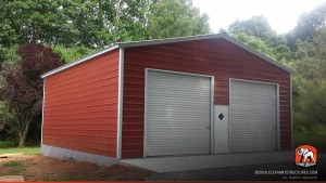 Two roll up garage doors on the front end of a metal building and one walk in door.