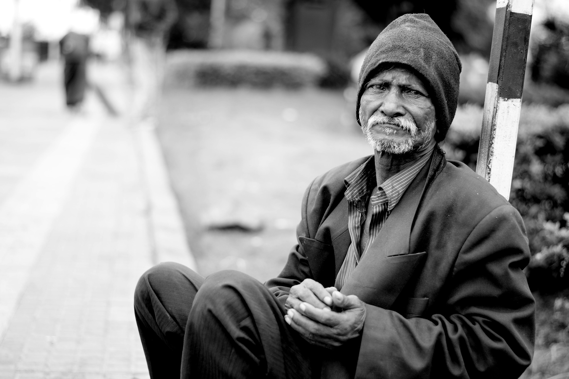 black and white image of a homeless man on the street